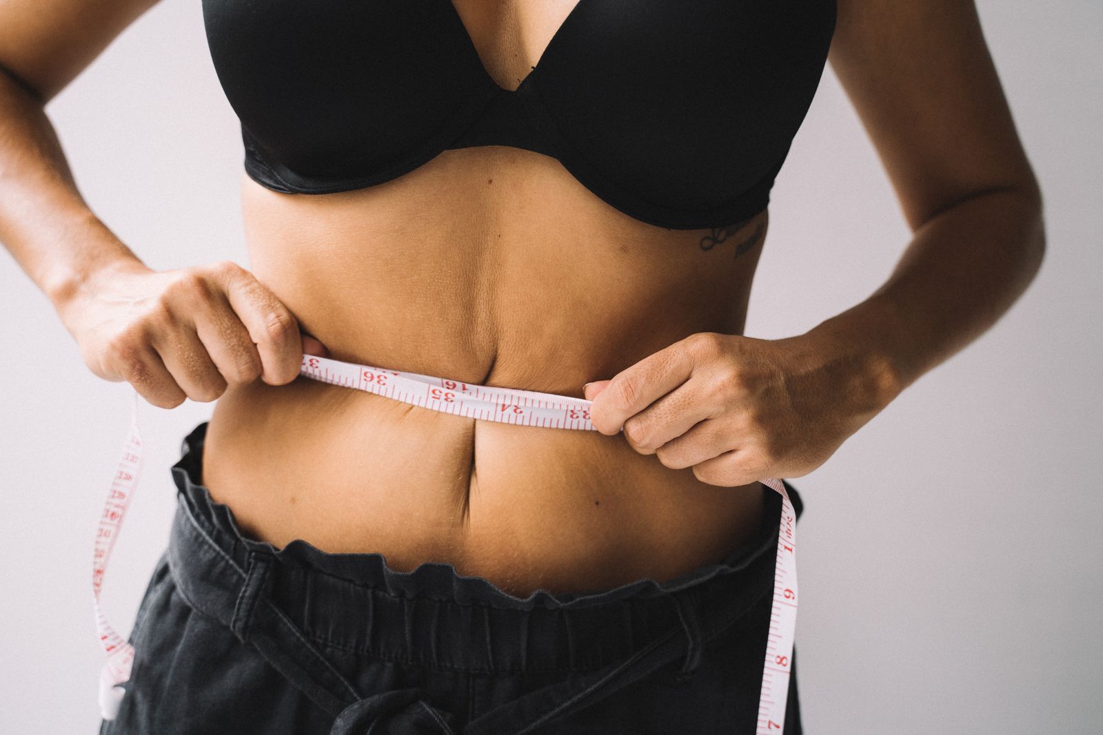 Abdomen con una cinta métrica alrededor de la cintura