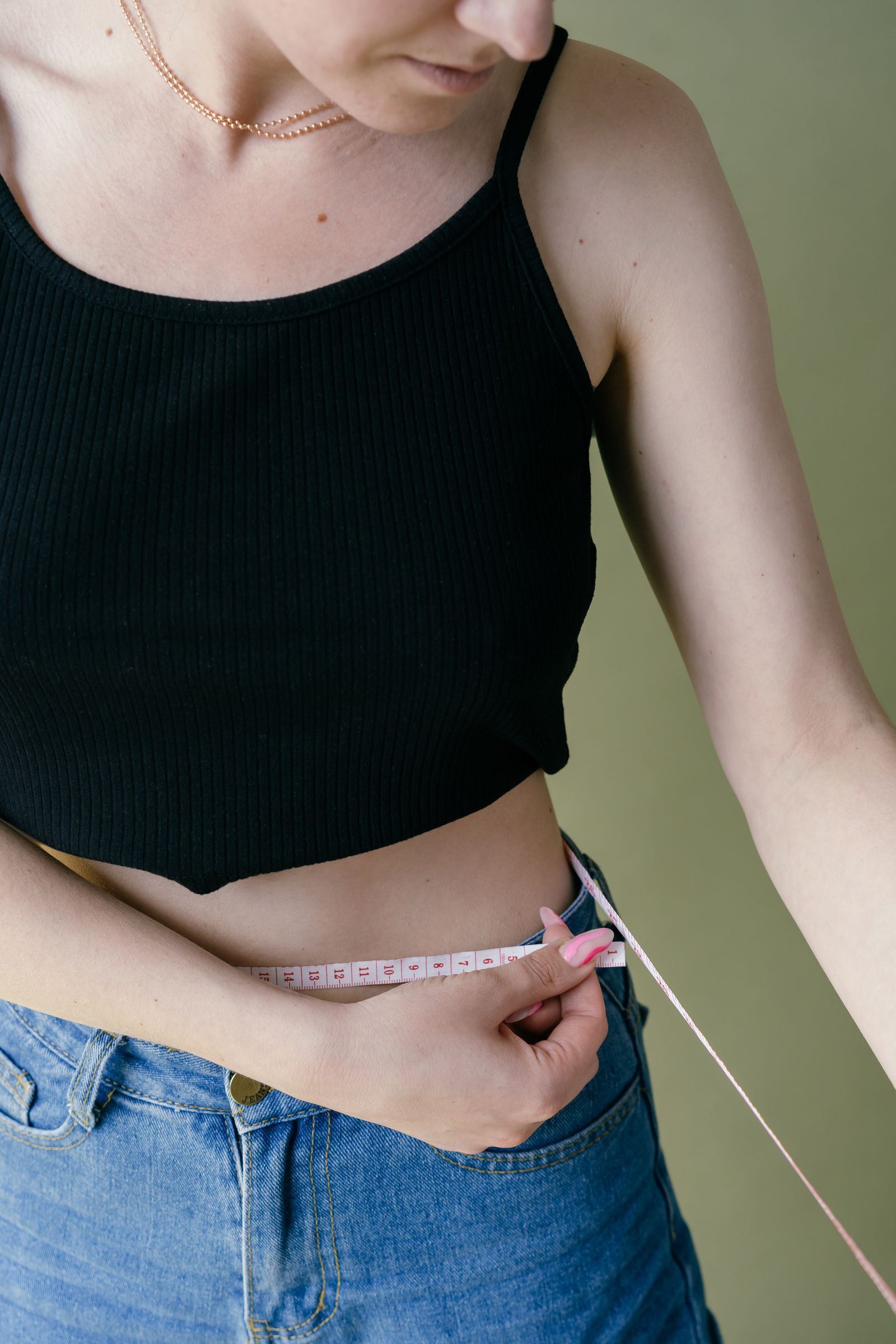 Mujer midiéndose la cintura con una cinta métrica